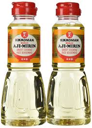 Two bottles of mirin which are a pale yellow color.