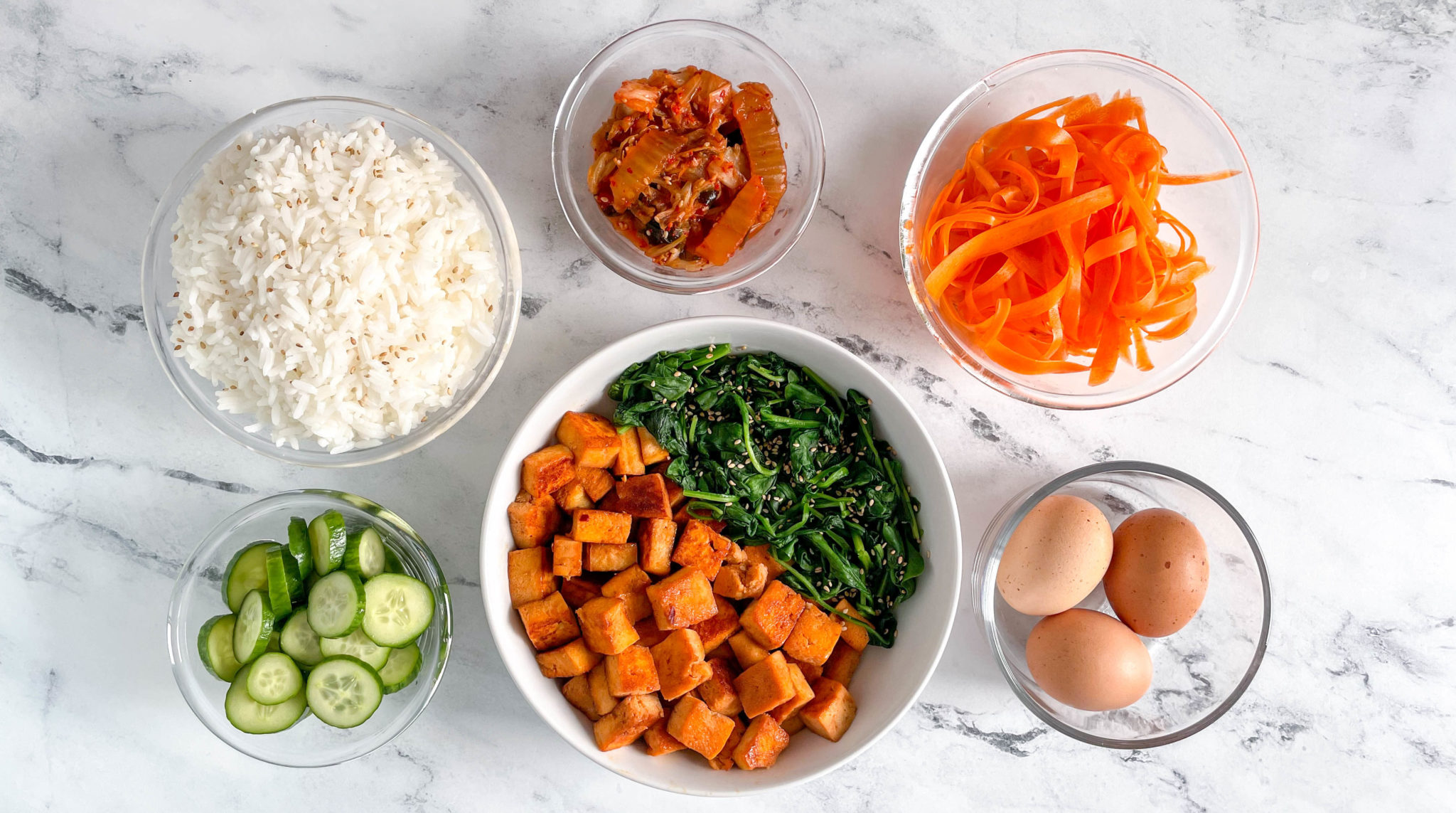 bibimbap bowls with rice, pickled veggies, tofu, and egg