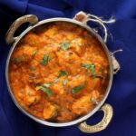 A bowl of red vegan tikka masala with tempeh is featured