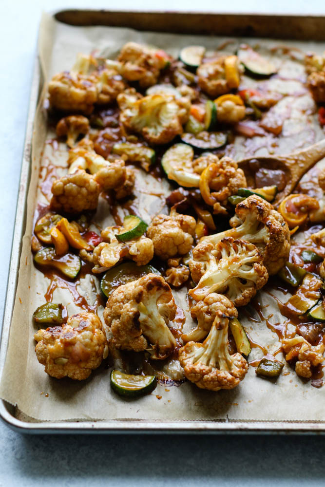 cauliflower and seasonal vegetables on a sheet pan with sweet and sour sauce