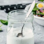homemade ranch dressing in a glass jar with a spoon